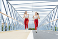 Two athletic women in sportswear is jogging on a bridge - PhotoDune Item for Sale