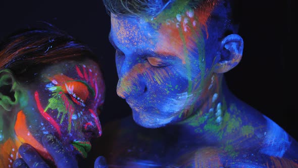 Couple with UV Drawings on the Skin in the Dark Under Light of Fluorescent Lamps