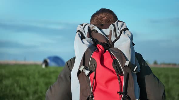 Closeup Active Male with Backpack Approaching to Camping Tent Back View