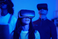 Young woman using virtual reality goggles together with her friends - PhotoDune Item for Sale