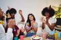 A young Latina celebrating her birthday together with her friends while they clap and celebrate - PhotoDune Item for Sale