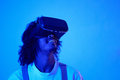 A young man wearing virtual reality goggles inside home looking up - PhotoDune Item for Sale