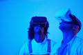 African American friends using VR glasses indoors illuminated with a blue light - PhotoDune Item for Sale