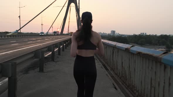 Back View of Jogging Young Woman on the Road