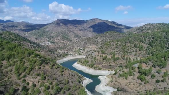 Wide aerial view pulling back over the beautiful mountain valley at Farmakas dam in Cyprus