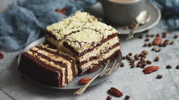 Homemade Layered Cake Sprinkled with White Chocolate. Served with Cup of Coffee on a Gray Concrete