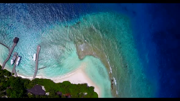 Aerial flying over travel of tranquil tourist beach lifestyle by turquoise ocean with white sandy ba