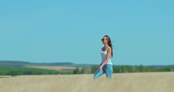 Beautiful Young Woman is Walking Across the Field She is Smiling and Happy