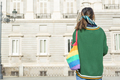 LGBT young person with pride bag looking at iconic building from behind - PhotoDune Item for Sale