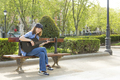 Joyful young Asian playing guitar in park - PhotoDune Item for Sale