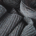 Knitted gray scarf and round skein of wool yarn. - PhotoDune Item for Sale