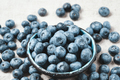 Blueberries with water drops in a ceramic bowl and scattered around. - PhotoDune Item for Sale