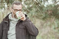 Bearded man drinks from reusable silicone mug. Camping, hiking, sustainable consumption. - PhotoDune Item for Sale