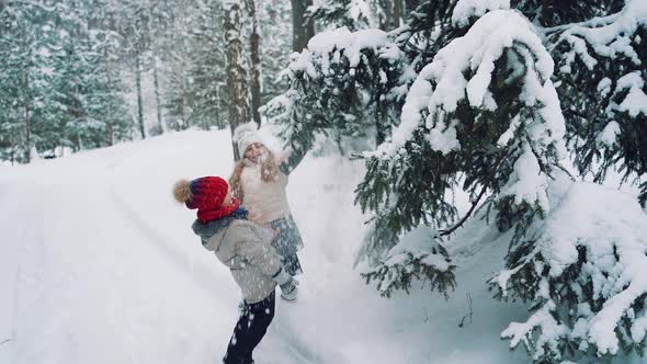 Happy little girls are playing in the beautiful park in winter.