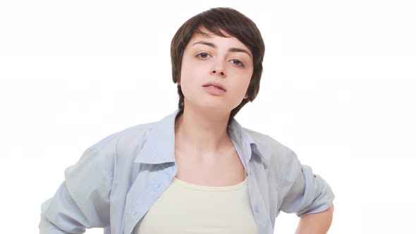 Arrogant Young Caucasian Female Standing Over White Background Chewing Gum and Staring at Camera