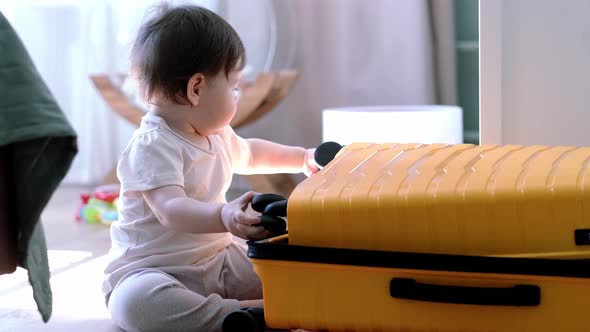 Baby Girl with Yellow Suitcase Baggage and Clothes Ready for Traveling on Vacation Child Playing