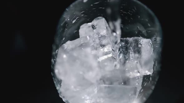 Pouring a Drink Into a Glass with Ice Cubes Isolated. Slow Motion 100Fps
