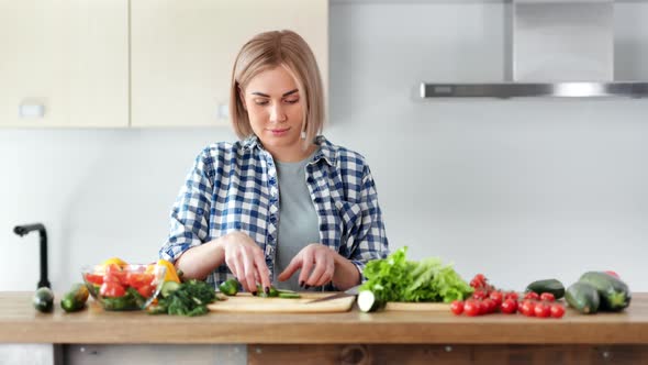 Beautiful Vegan Woman Cooking Fresh Salad and Trying Vegetables Looking at Camera Medium Shot