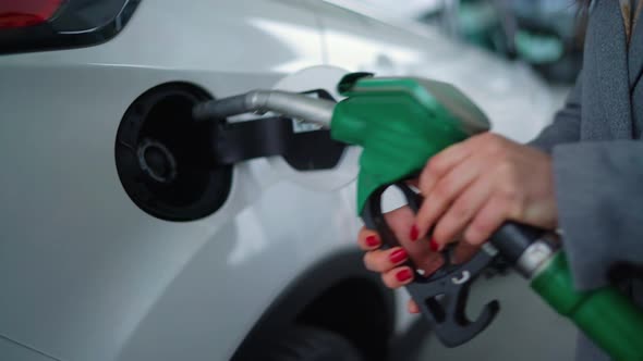 Woman Fills Petrol Into Her Car at a Gas Station Closeup