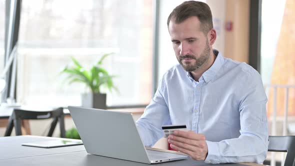 Online Payment Success By Young Man on Laptop in Office 