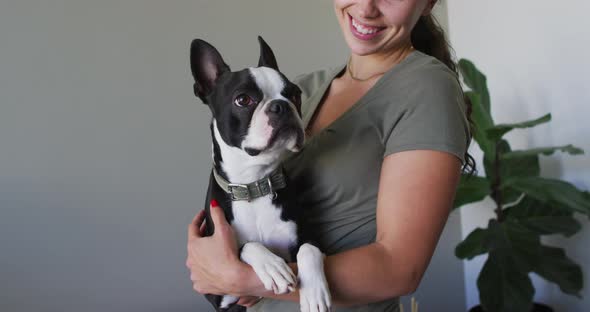 Happy caucasian woman is playing with his dog at home