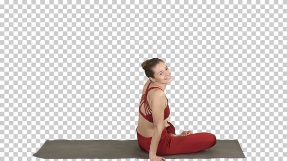 Sporty woman practicing yoga lotus pose turning to camera