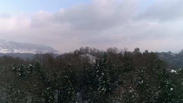 Aerial revealing shot of frozen lake and fairy tale castle in the distance at winter