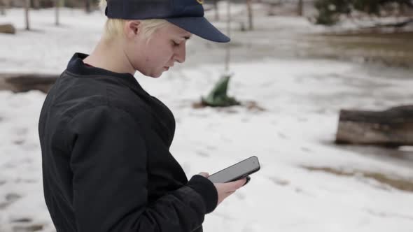 A person checking their phone in the cold.