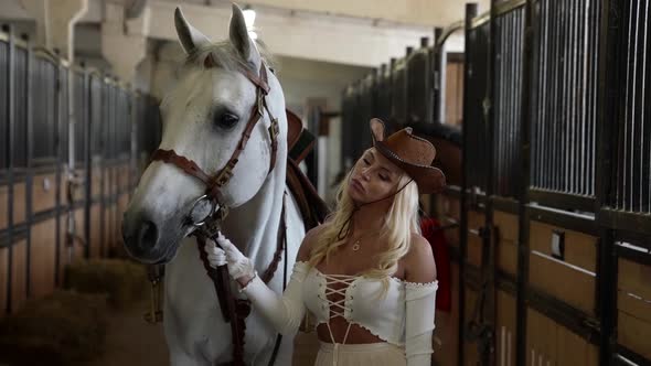 Portrait of Sexy Woman and White Horse Inside Barn on Modern Ranch