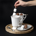 A woman's hand stirs hot chocolate with marshmallows and chocolates skewers - PhotoDune Item for Sale