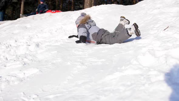 A Child Rides and Plays on a Snowy Mountain