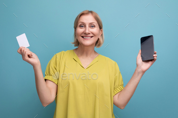 blond mature woman makes a purchase online paying with her money card