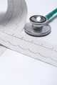 Regular elektrocardiogram and a stethoscope on white background close up - PhotoDune Item for Sale