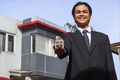 Property agent in suit holding a house model in hand  - PhotoDune Item for Sale