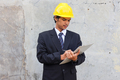 Male Asian engineer with hardhat writing on a clipboard - PhotoDune Item for Sale