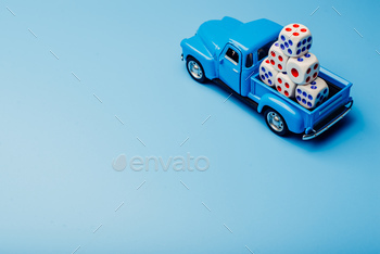 A car with dice on a blue background. Game concept