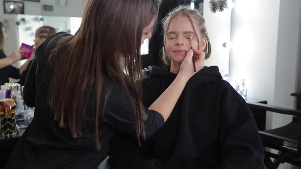 Woman Make Makeup for Attractive Blond Hair Woman in Studio