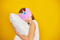Nice teenage girl in white pyjamas with a violet sleeping mask embraces a pillow - PhotoDune Item for Sale