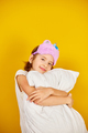 Nice teenage girl in white pyjamas with a violet sleeping mask embraces a pillow - PhotoDune Item for Sale