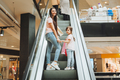 mother and little girl on the escalator in the mall.Mother and daughter in the mall.  - PhotoDune Item for Sale