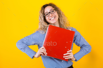 ped shirt and eyeglasses isolated on orange background holding big folder with files graduate or course work report relief happiness concept.