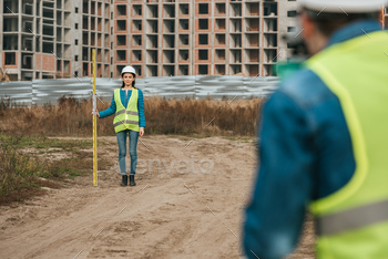 Selective focus of surveyors measuring land on construction site