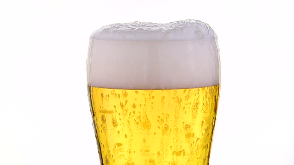 Pouring beer in glass over white