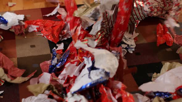Kids playing in piles of Christmas wrapping paper alt