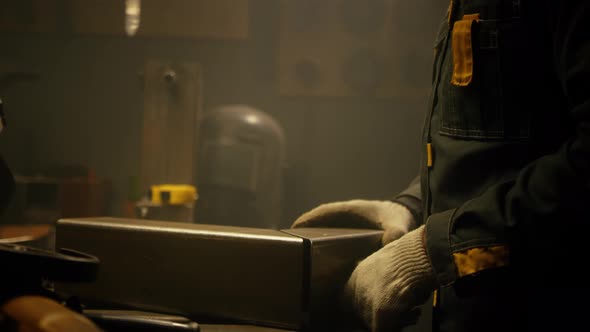 A skilled industrial worker checks a metal part