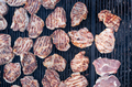 closeup of pork slices being grilled on black iron barbeque grate outdoors - PhotoDune Item for Sale