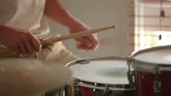 Drummer practicing medium speed parradiddle on snare drum.