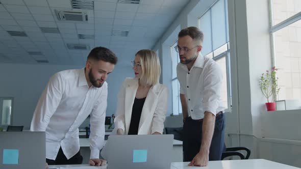 Three Partners Discuss Their Work in an Office