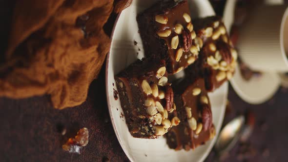 Chocolate Cake with Caramel Frosting, Pecans and Hot Coffee, on Rustic Background. Freshly Baked