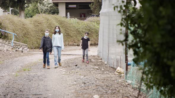 Coronavirus pandemic - kids walking outdoors with face masks to avoid contagion